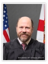 Portrait of Judge John Waters - wearing back robe with American and State flag in background