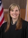 Portrait of Judge Rachelle E. Williamson in judges black robe with American and State of Florida flags behind her.